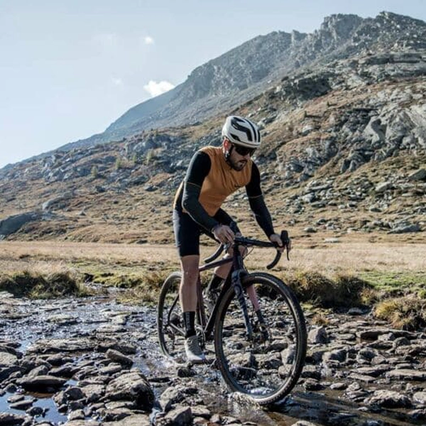 Homme sur un vélo en montagne au bord d'une rivière