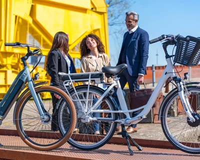 Groupe de personnes discutent derrière deux vélos électriques